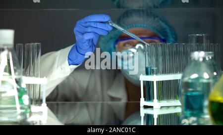 Des gouttes scientifique agent chimique dans le tube à essai des liquides bleu Banque D'Images