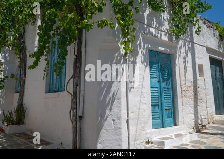 Scène de village typique de l'île grecque de Filoti et étapes le long pathwith crazy paving étroite surplombant les branches et les feuilles d'entrée de maisons avec bl Banque D'Images