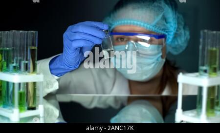 Scientist holding bouteille avec injection antibiotique liquide transparent, études Banque D'Images