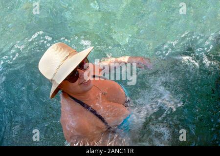 Pamukkale, Turquie - 7 septembre, 2019 : Belle femme adulte dans un chapeau de paille se baigne dans la piscine de Cléopâtre Banque D'Images