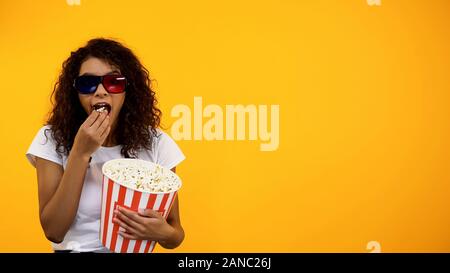 Jeune fille afro-américaine dans les lunettes 3D avec le pop-corn en regardant exposition de comédie, modèle Banque D'Images