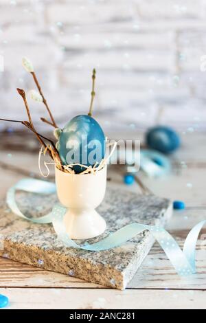 Oeufs de Pâques dans un bâtiment moderne en classique bleu couleur sur table en bois. Joyeuses Pâques le temps. Creative décoration de Pâques. Banque D'Images