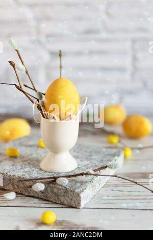 De couleur jaune des oeufs de Pâques sur table en bois. Joyeuses Pâques le temps. Creative décoration de Pâques. Banque D'Images