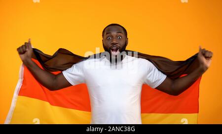 L'homme afro-américain holding drapeau allemand, à l'appui de l'équipe de fan de sport favorite Banque D'Images