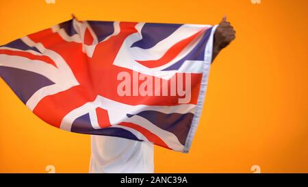 Holding fan de sport drapeau britannique, encourageant pour l'équipe favorite de victoire, vue arrière Banque D'Images