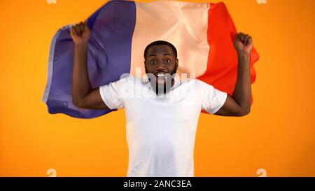 L'homme afro-américain holding drapeau français, à l'appui de l'équipe nationale de football Banque D'Images