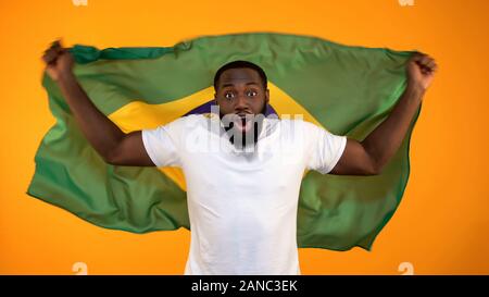 L'homme afro-américain holding drapeau brésilien, le soutien de l'équipe nationale de sport Banque D'Images