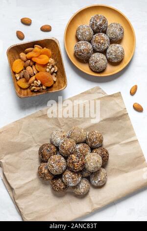 Des boules d'énergie avec les abricots secs, les raisins secs, les dattes, les pruneaux, noix, amandes et noix de coco. Une saine. Mise à plat, vue du dessus. Banque D'Images