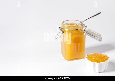 Confiture de fruits délicieux faits maison dans un bocal en verre et bol sur fond blanc. Copier l'espace. Vue de côté. Banque D'Images