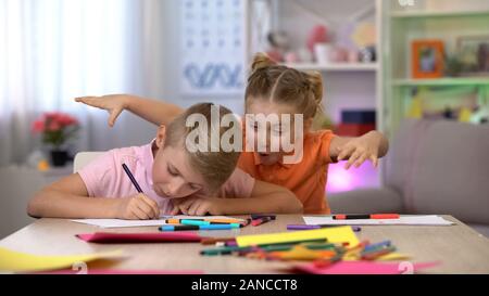 Frère d'effarouchement Girl studying at table, hyperactivité, déficit d'attention de l'enfant Banque D'Images