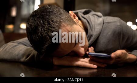 Homme fatigué dormir sur table dans un restaurant, holding smartphone, style de vie occupé Banque D'Images