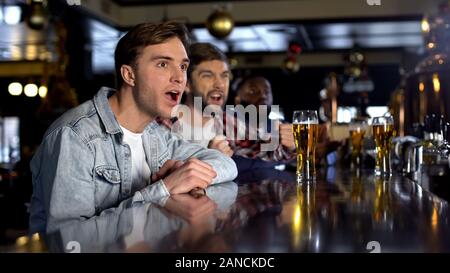Ami masculin tournoi de regarder dans un pub, ils applaudissent à la victoire de l'équipe nationale Banque D'Images