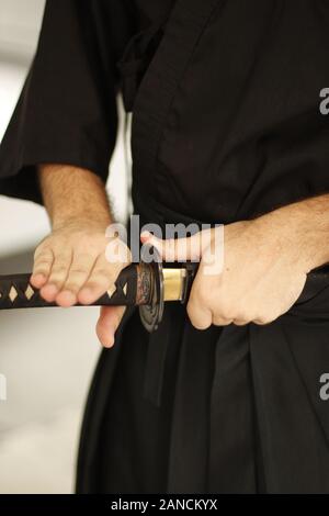 Près de deux hommes's hands holding iaido sword Banque D'Images