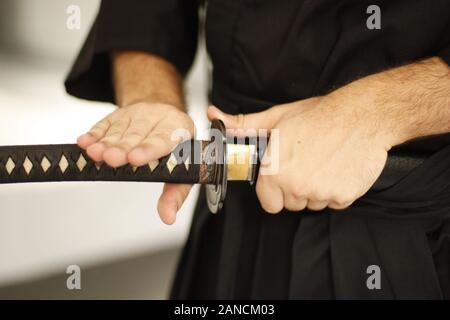 Près de deux hommes's hands holding iaido sword Banque D'Images