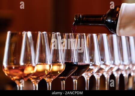 Verres à vin dans une rangée. Verser le vin. Table Buffet fête de la dégustation de vins. Vie nocturne, Fête et culture concept. L'horizontale Banque D'Images