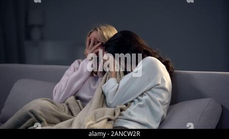 Deux belles filles peur en regardant un film d'horreur la nuit, effrayant épisode Banque D'Images