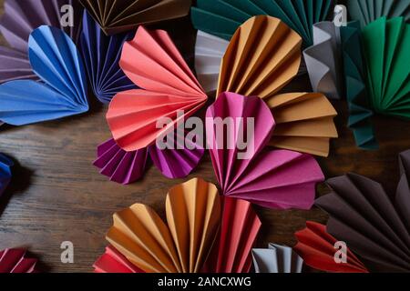 Vue de dessus des coeurs en papier faits main colorés disposés sur une surface en bois Banque D'Images