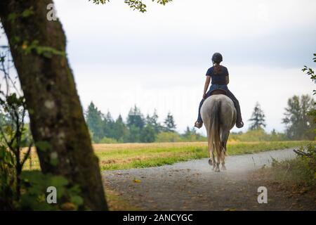 Vue arrière de la cycliste sur un sentier tranquille. Banque D'Images