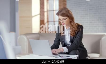 Pretty woman working on laptop in office coûteux, responsable Banque D'Images