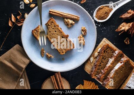 Passage tiré d'un plaque bleue avec une tranche de gâteau à la citrouille avec un bâton de cannelle, d'une fourchette et les noix. Il y a des bâtons de cannelle et powde Banque D'Images