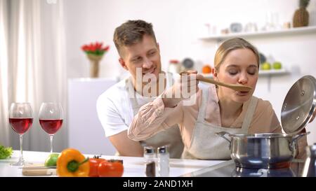 Couple heureux ensemble dans la cuisine, cuisine, soupe dégustation femelle alimentation saine Banque D'Images