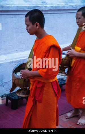 Les moines et les touristes participent à sai bat (matin l"aumône), Luang Prabang, Laos. Banque D'Images