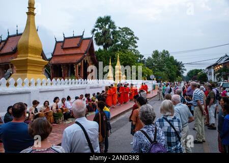 Les moines et les touristes participent à sai bat (matin) donnant l'aumône, Wat Sesnsoukharam, Sakkaline Road, Luang Prabang, Laos. Banque D'Images