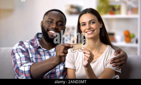 Cheerful mixed-race couple holding paper landau, un enfant attend, Dream Banque D'Images