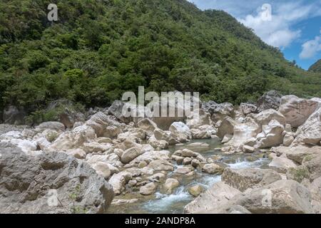 La rivière Tinipak traverse un terrain montagneux avec des rapides et une grotte avec une piscine naturelle. Banque D'Images