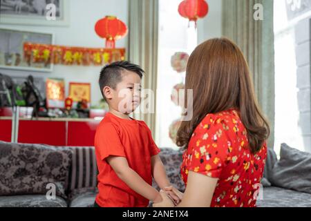 Asian mother holding hand et dire par son fils pour fêter le nouvel an Banque D'Images