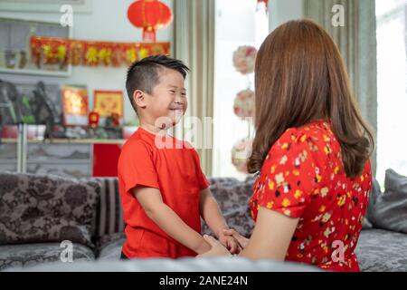 Mère chinoise asiatique avec happy holding hand et dire par son fils pour fêter le nouvel an Banque D'Images