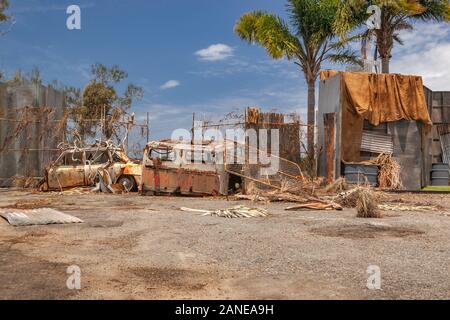 Voiture rouillée et appareil près d'une clôture en junk, Wrecking Yard avec piscine cellier et palmiers vue, lieu abandonné, Gold Coast, Australie Banque D'Images