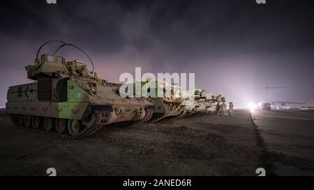 L'ARMÉE AMÉRICAINE M2 et véhicules de combat Bradley M1A1 Abrams tanks sont garés à côté d'une ligne de vol dans la zone de responsabilité, le 3 janvier 2020. L'USCENTCOM dirige et permet aux opérations et activités militaires avec les alliés et partenaires afin d'accroître la sécurité et la stabilité régionale à l'appui durable d'intérêts américains. (U.S. Air Force photo de Tech. Le Sgt. Daniel Martinez) Banque D'Images