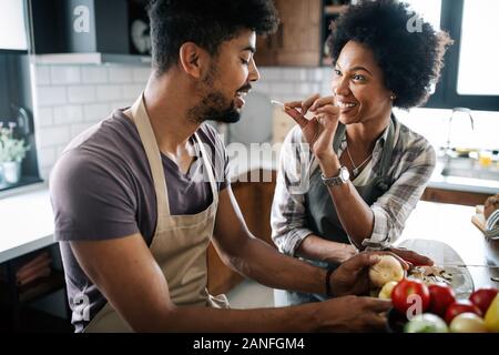 Beau jeune couple la cuisson des aliments sains ensemble à la maison. Avoir du plaisir dans la cuisine. Banque D'Images