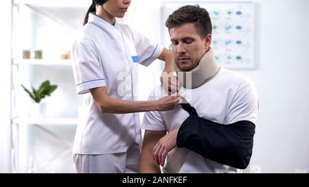 Fixation du bras du patient mâle orthopédiste sling en position droite, rehab après un traumatisme Banque D'Images