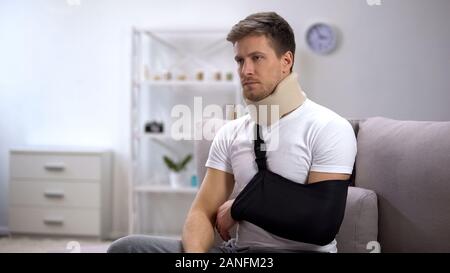 Dans l'homme collier cervical mousse et bras sling malheureuse à cause de l'invalidité, rehab Banque D'Images