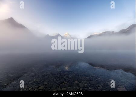 Mount Assiniboine en bleu sur le lac Magog reflet brumeux au parc provincial, BC, Canada Banque D'Images