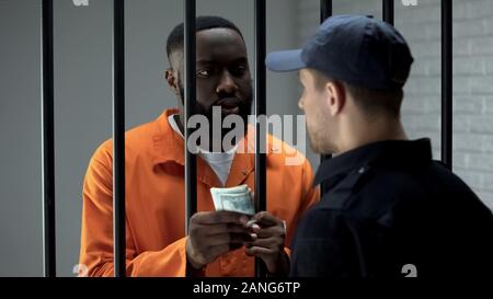 African American dollar cash à donner prisonnier guard, la corruption en prison, pot-de-vin Banque D'Images