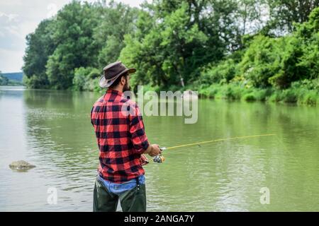 Je viens de poissons. passe-temps et les activités sportives. pothunter. week-end d'été. La pêche au gros. pêcheur avec canne à pêche pêcheur barbu. dans l'eau. man fl Banque D'Images