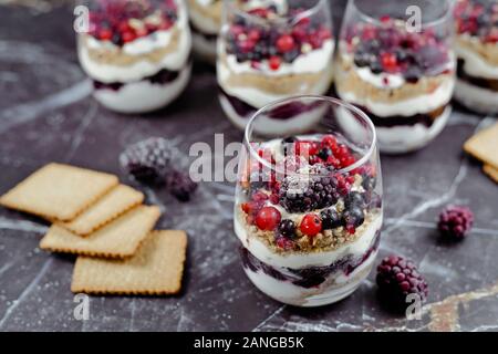 Des fruits rouges en couches, cookie et crème dessert gâteau au fromage dans les verres Banque D'Images