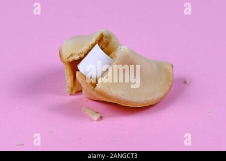 Ouvrir biscuit de fortune avec le papier blanc à l'intérieur sur fond rose Banque D'Images