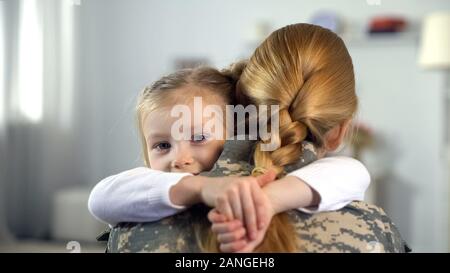 Little daughter hugging soldier des uniformes de camouflage, la guerre homecoming Banque D'Images