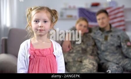 US military couple admiring peu cute fille looking at camera, Banque D'Images