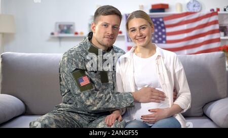 L'homme en uniforme militaire de caresser le ventre de femme enceinte, concept de nation américaine Banque D'Images