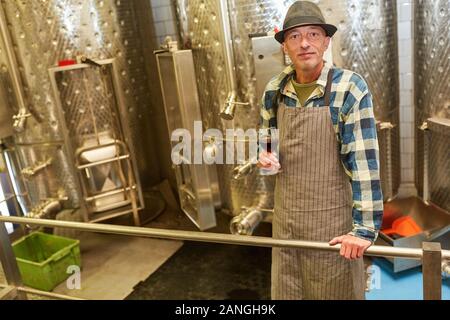 Maître vinificateur ou de vin avec un verre de vin rouge tandis que la fabrication du vin Banque D'Images