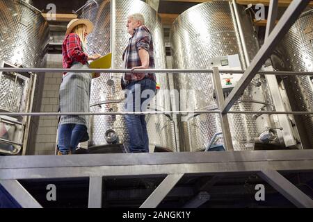 Vigneron et de la stagiaire avec en face d'une cuve de fermentation dans la cave Banque D'Images