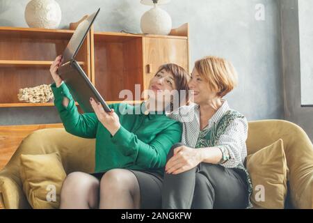 Deux femmes mature le choix et l'achat en ligne, e-commerce Banque D'Images