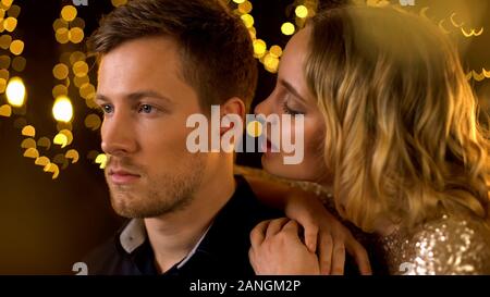 Pretty woman whispering compliments pour petit ami à parti, l'homme séduisant, escort Banque D'Images