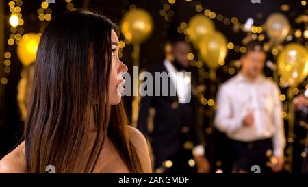 Femme asiatique malheureux à la recherche de personnes à danser dans une boîte de nuit, l'ennui Banque D'Images