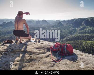 Prendre le temps de pause Randonneur pour l'alimentation. Amener l'homme splastic fort avec sandwich et fruits, et aussi l'acier inoxydable thermos avec du thé sur le sommet rocheux. Grand adven Banque D'Images